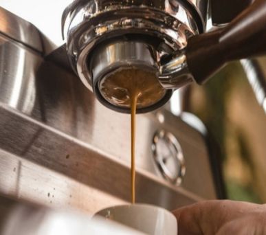 Close-up of espresso pouring from a machine into a cup.