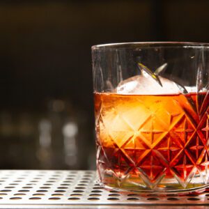 Crystal glass with whiskey and ice cube.