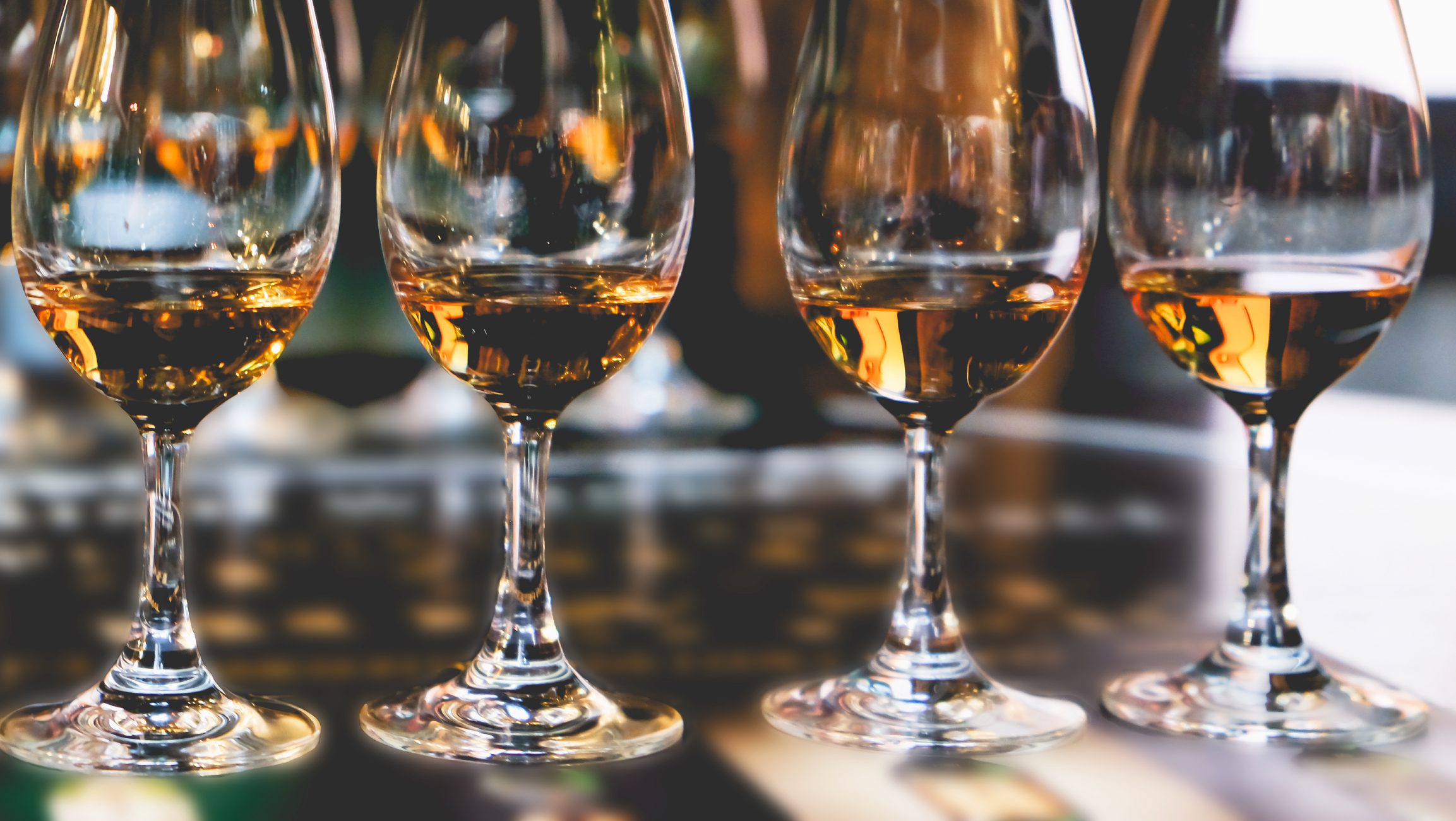 Glasses of whiskey arranged on a table.